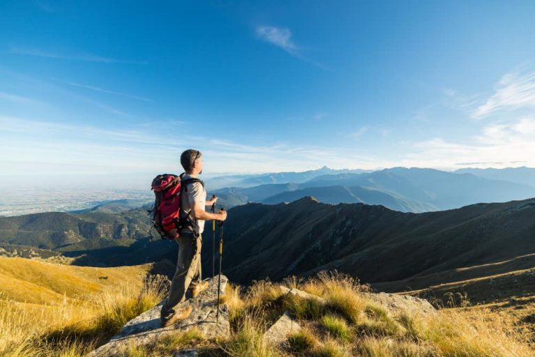 male hiker at the top of a mountain enjoying the view.