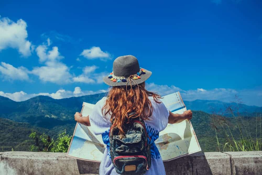 woman traveller looking at the horizon with a map in her hands