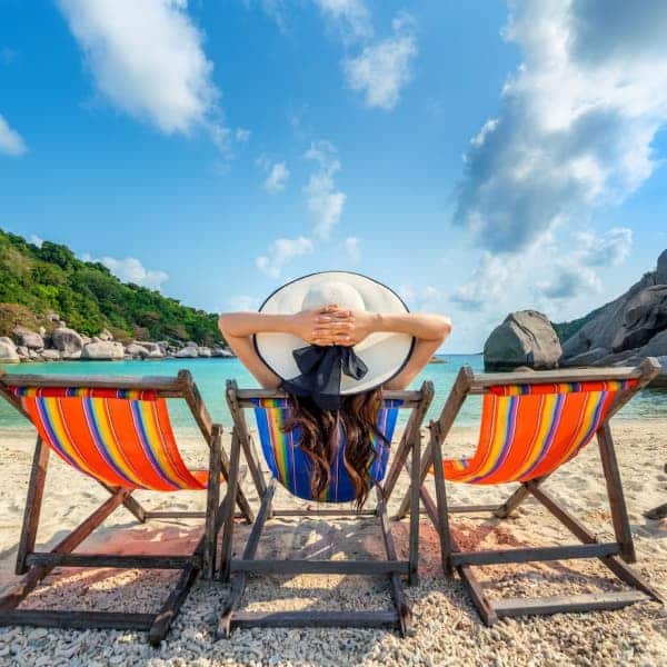 woman resting on a beach chair looking at the ocean